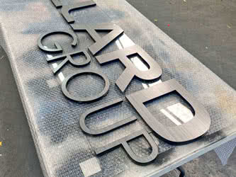 Cropped view of a business sign, resting on a workbench