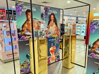 A perfume visual merchandising display inside a shopping centre, front view from left