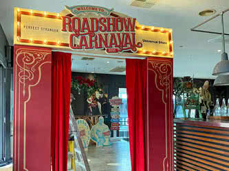 A tall Universal Roadshow-branded display with curtain that people can walk through