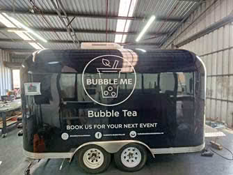 Side view of an enclosed food and drink trailer, belonging to Bubble Me Tea